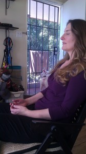 Sindi meditating with dog in background